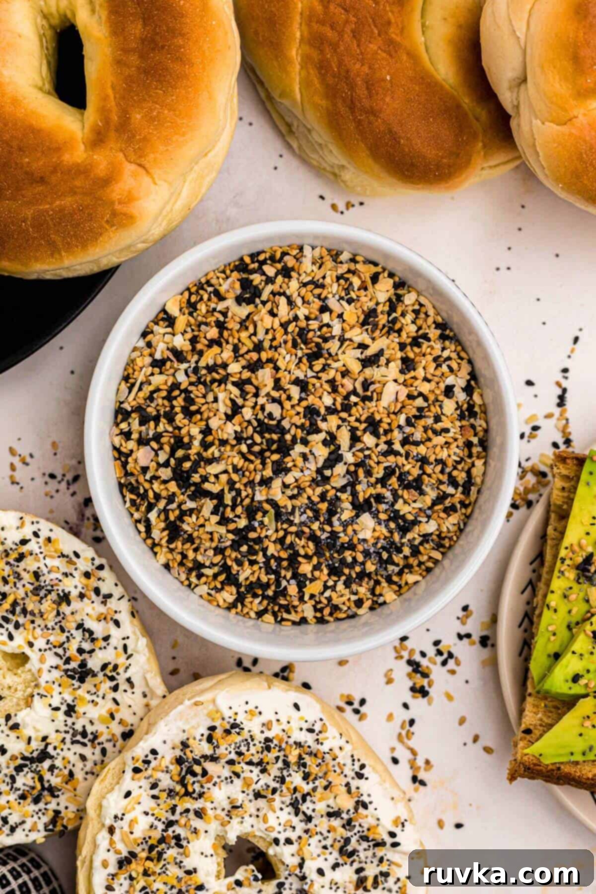 DIY Everything Bagel Seasoning 2 Everything Bagel Seasoning in a small bowl surrounded by bagels and avocado toast.
