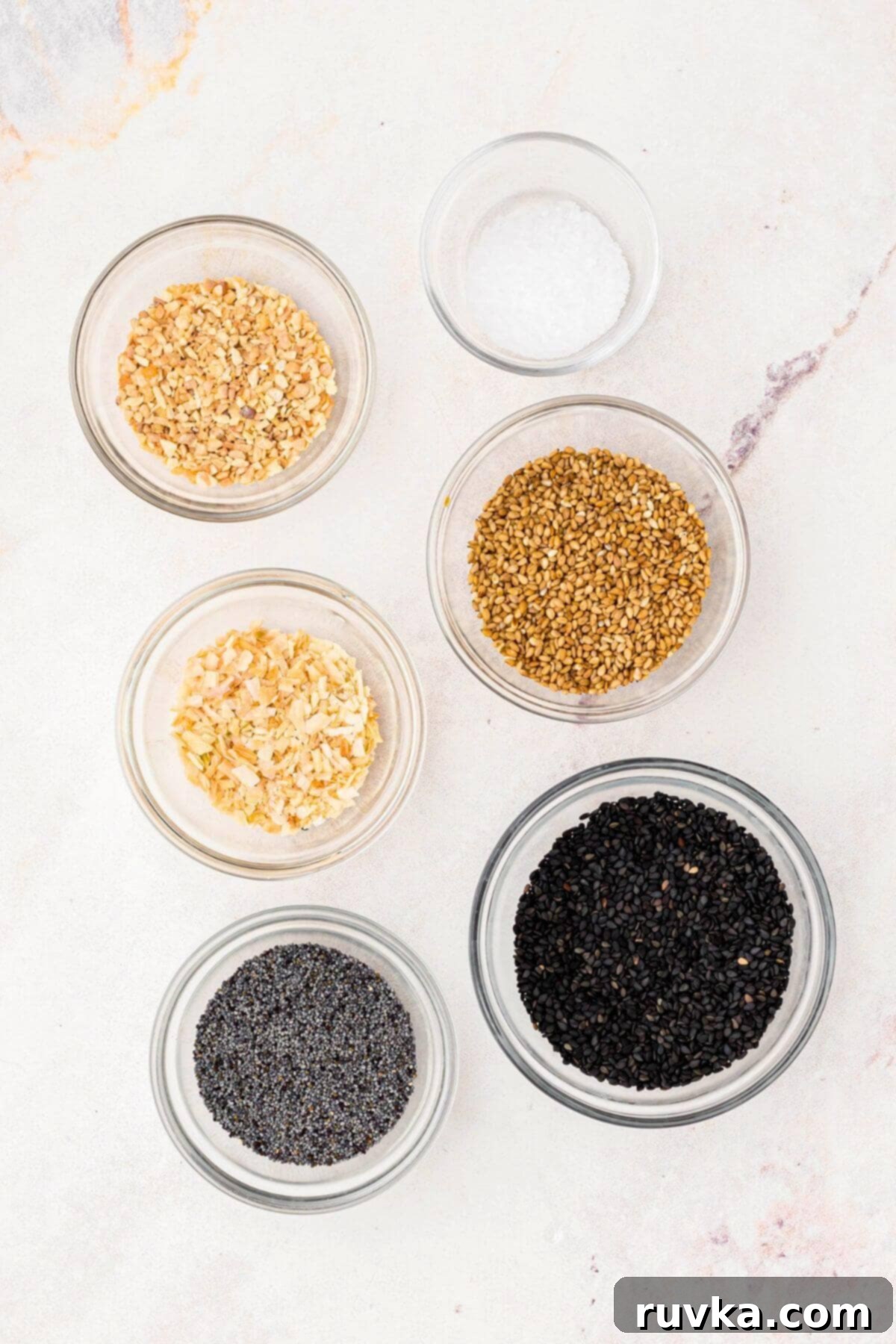DIY Everything Bagel Seasoning 3 Seeds and seasonings measured out in small glass bowls.