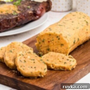 Robust Cowboy Butter 10 Golden seasoned butter rolled and sliced on a cutting board.