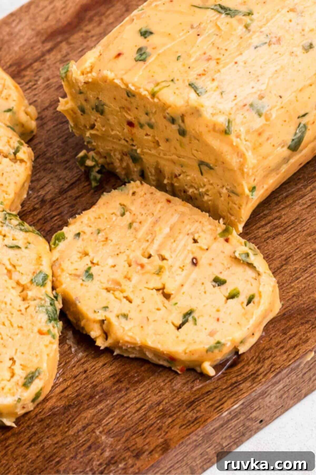 Robust Cowboy Butter 9 Close up photo of block of butter with seasonings mixed inside and sliced.