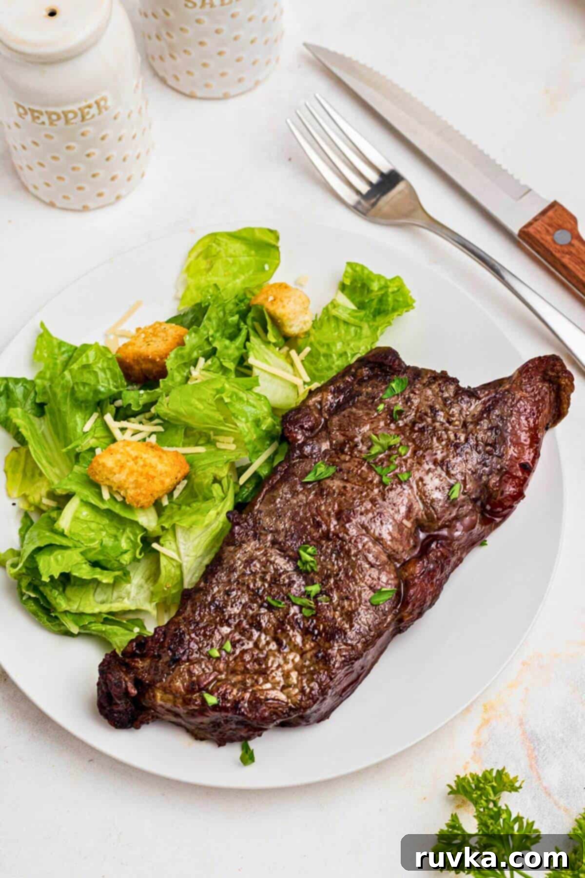 Air Fryer New York Strip Steak cooked to perfection Perfectly cooked, juicy New York strip steak resting on a cutting board, ready to be sliced.