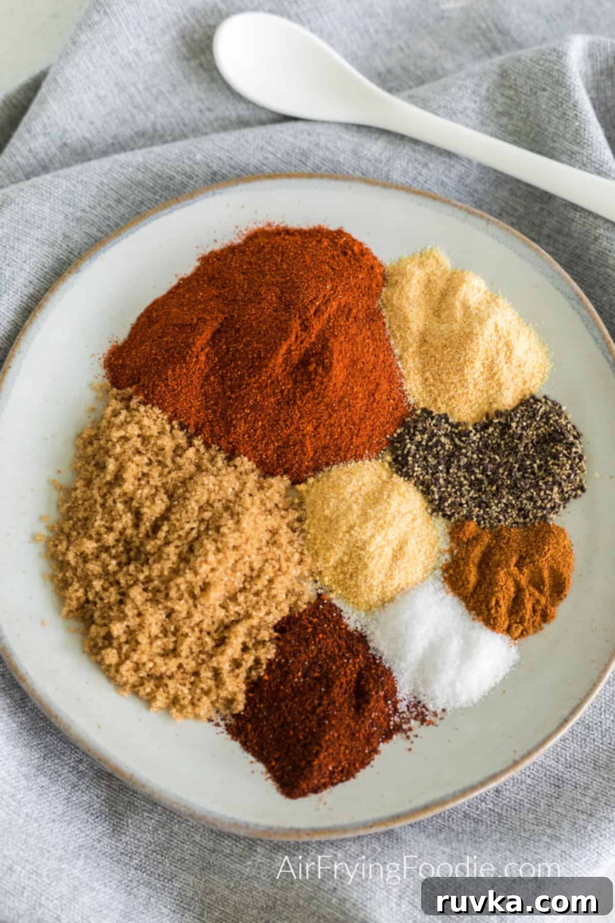 Master Your Own BBQ Rub 4 Seasonings measured out on a plate to combine to make a homemade bbq rub.