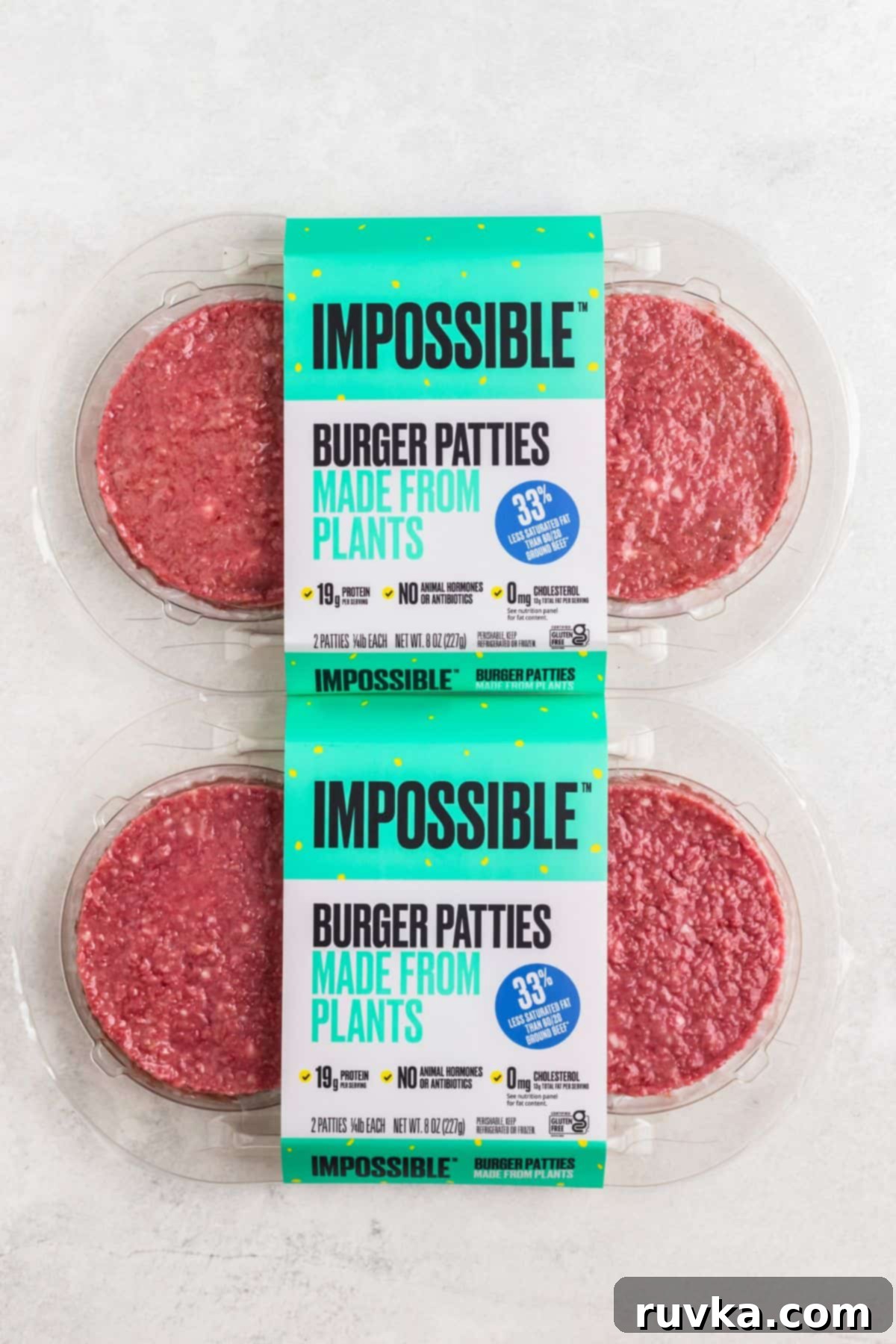 Crispy Air Fryer Impossible Burgers 3 Two raw Impossible Burger patties in their original packaging, resting on a white marble countertop, ready for cooking.