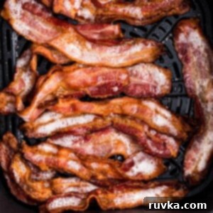 Air Fryer Frozen Bacon Hack 8 Golden crispy bacon in the air fryer basket after being cooked from frozen.