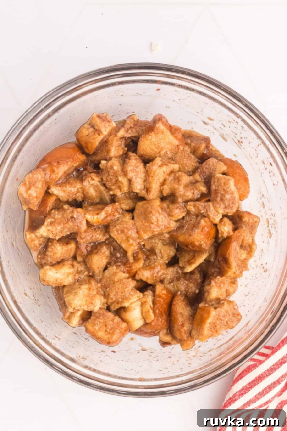 Crispy Air Fryer French Toast Bites 3 Bites of bread in a large bowl mixed with egg and vanilla to make French toast bites.