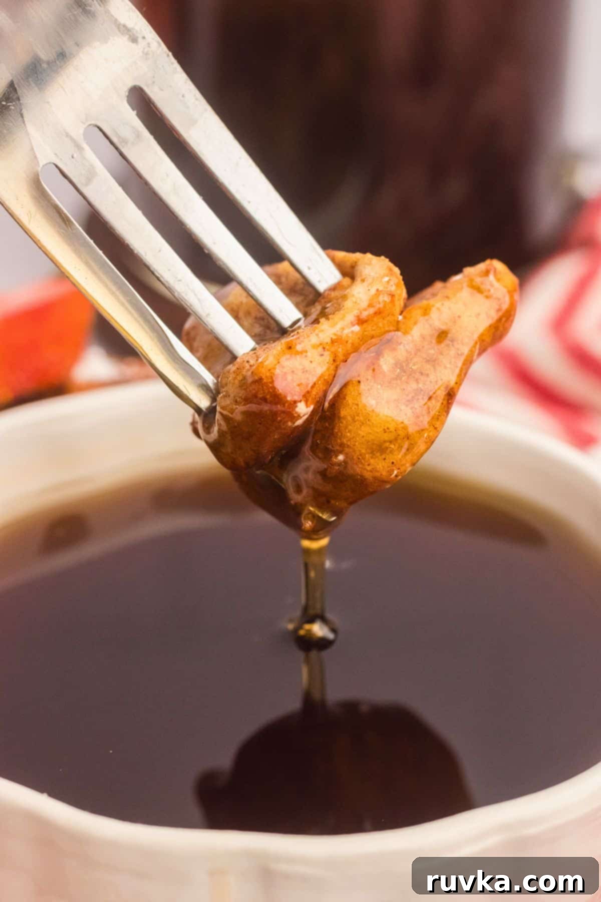 Crispy Air Fryer French Toast Bites 7 Golden French toast bites on a fork being dipped into syrup.
