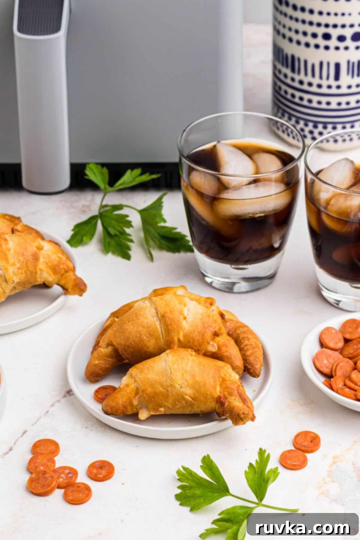 Air Fryer Pizza Crescent Bites 2 Golden pizza crescent rolls on a small white plate, ready to be enjoyed.