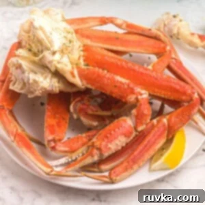 Point-Friendly Air Fryer Dishes 9 Orange crab legs on a white plate, served with lemon slices and sprinkled with parsley flakes.