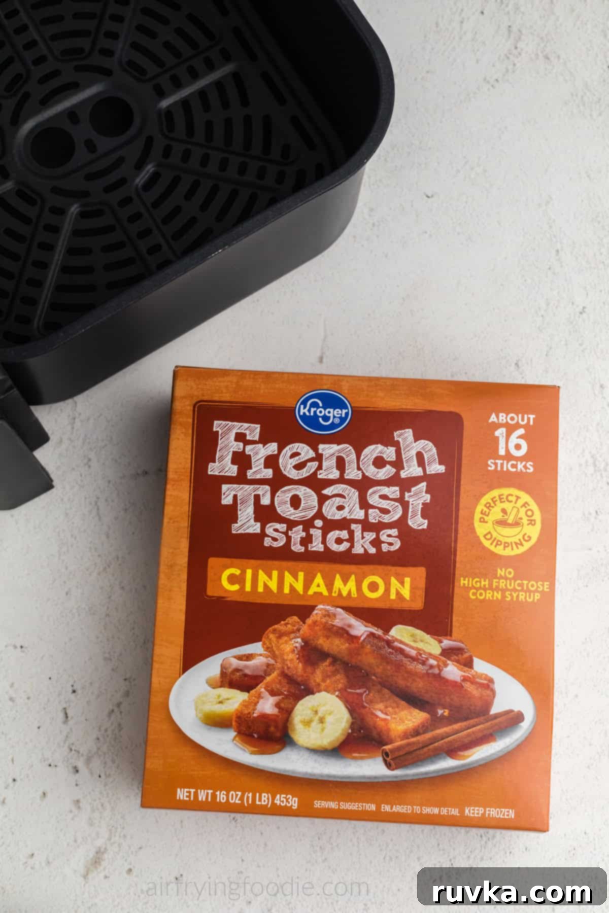 Crispy Air Fryer Frozen French Toast Sticks 3 Overhead photo of frozen french toast sticks in a box and a basket of an air fryer.