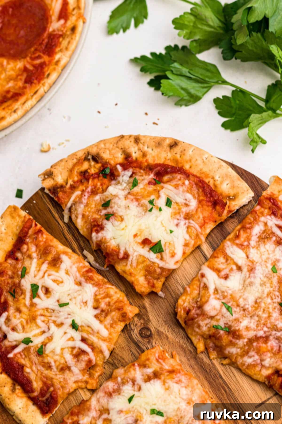Crispy Air Fryer Pita Pizza 2 Cheesy pizza with a golden crust of pita bread on a cutting board on a marble table.