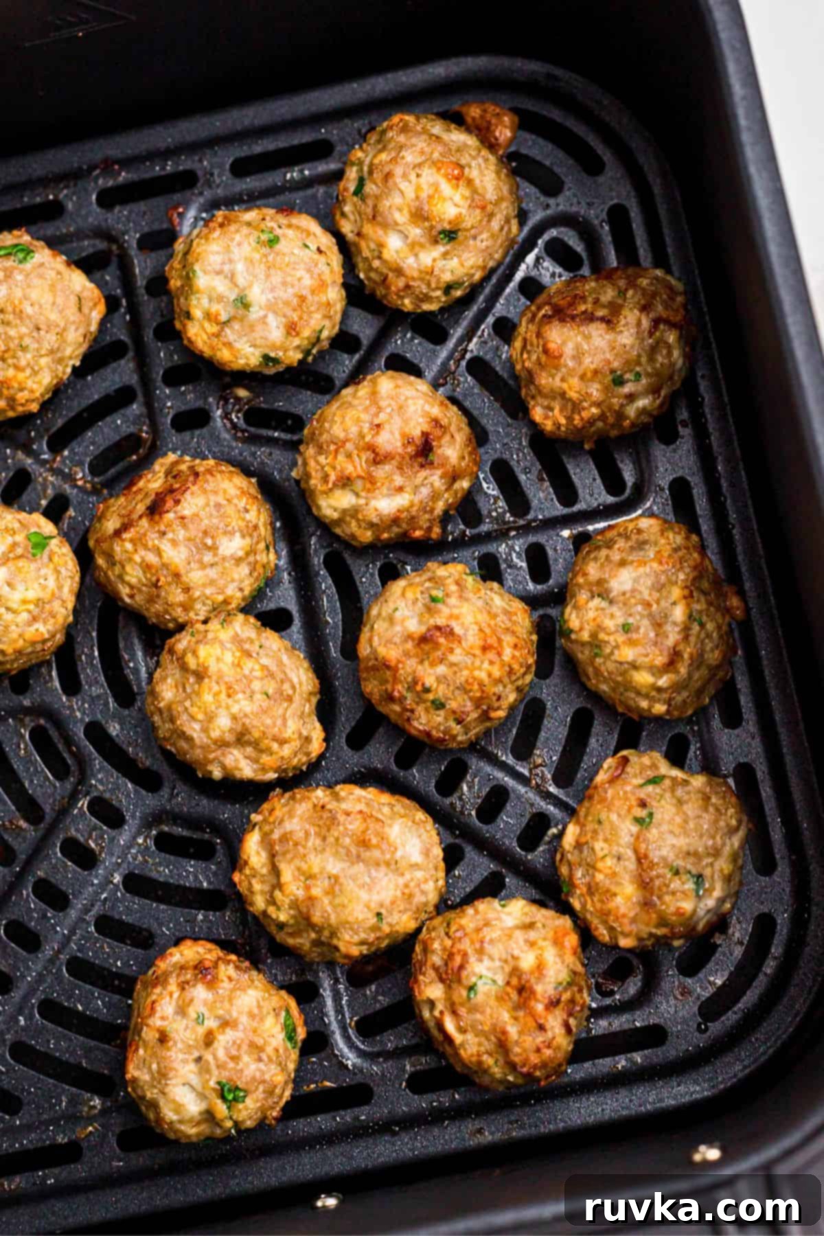 Crispy Air-Fried Greek Meatballs 6 Juicy, golden Greek meatballs in the air fryer basket after being cooked.