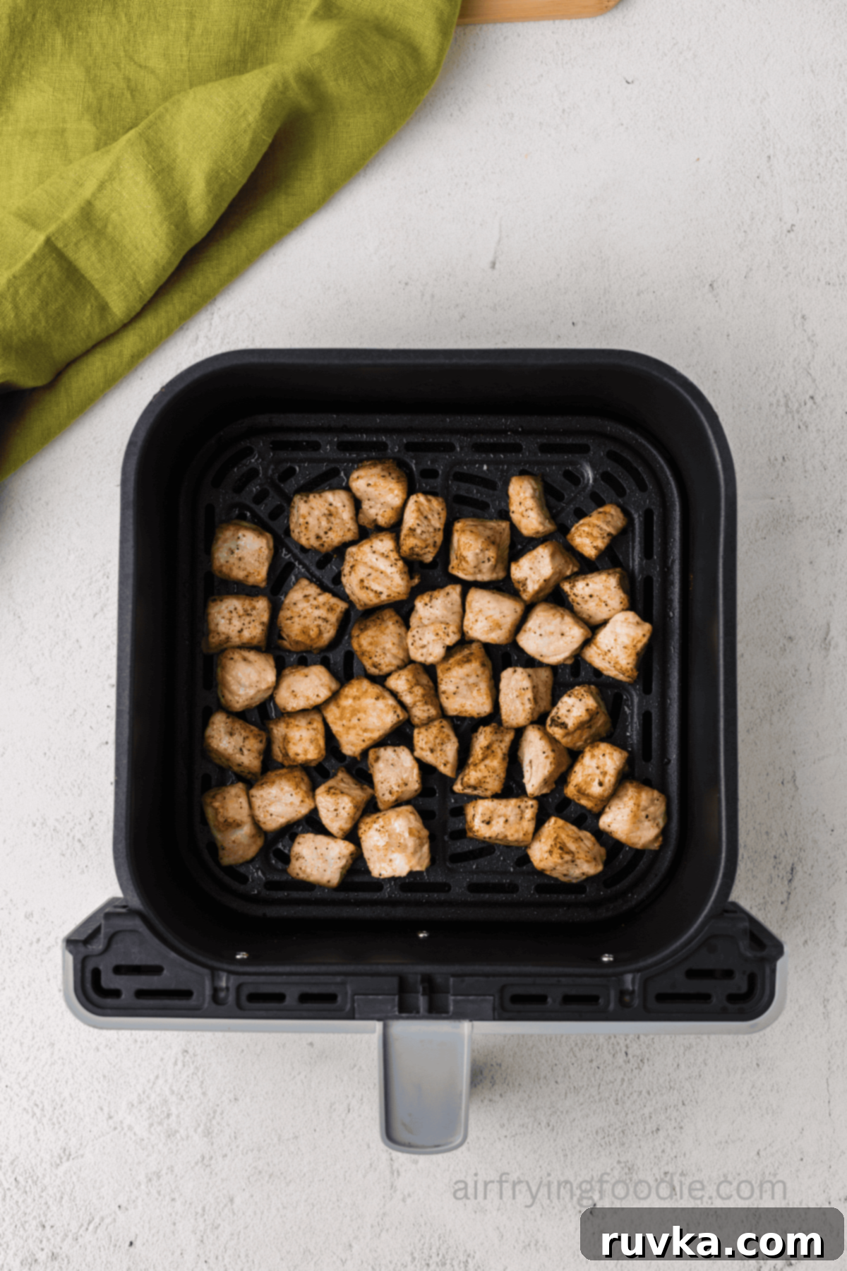 Crispy Air Fryer Pork Cubes 7 Cooked pork chop bites in the basket of the air fryer.