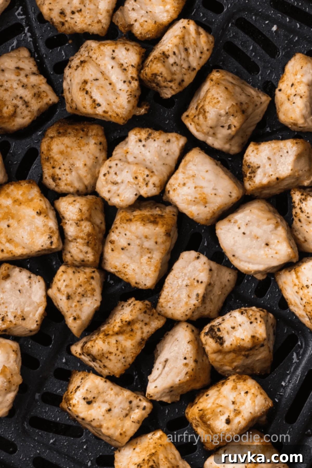 Crispy Air Fryer Pork Cubes 9 Close up of pork chop bites in the air fryer basket.