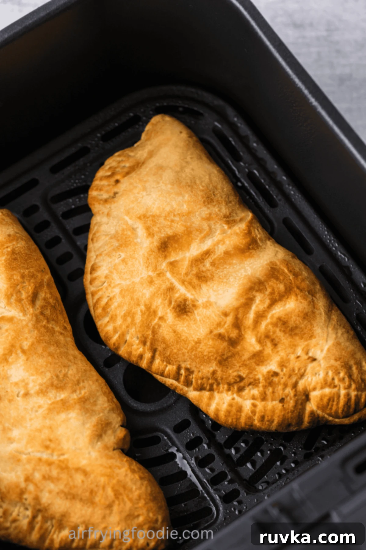 Air-Fried Calzone Pockets 8 Calzones in air fryer basket.