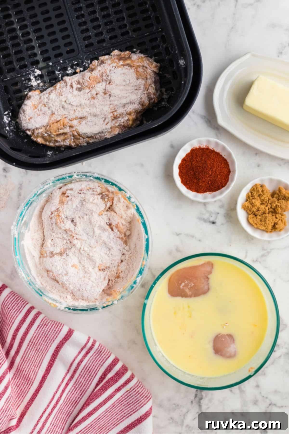 Crispy Air Fryer Nashville Hot Chicken 4 Pieces of chicken being dredged through flour, eggs, and other ingredients to make a crispy coating.