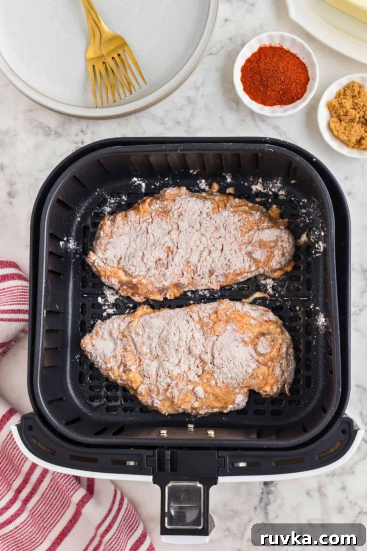 Crispy Air Fryer Nashville Hot Chicken 5 Chicken breasts coated and battered in an air fryer basket, before being cooked.
