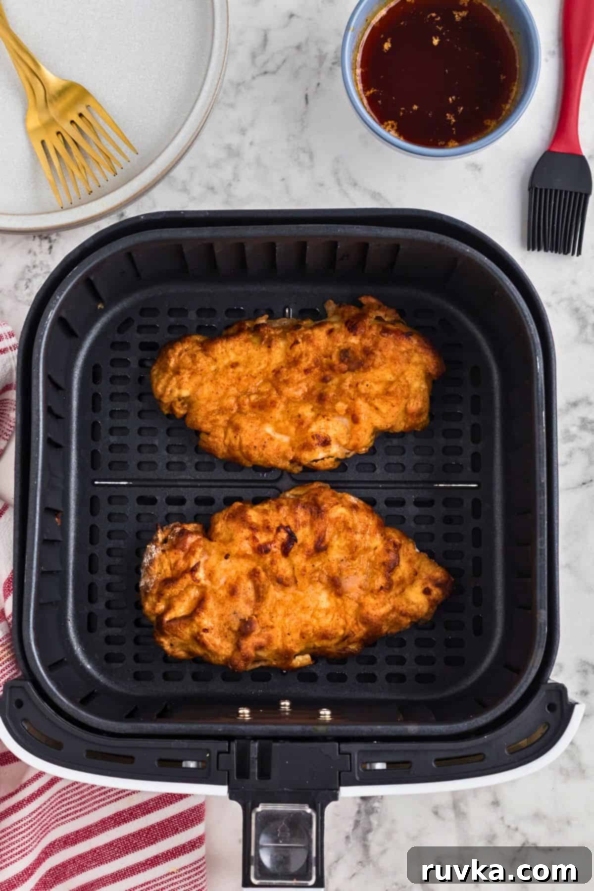 Crispy Air Fryer Nashville Hot Chicken 6 Crispy golden chicken breasts in the air fryer basket after being cooked.