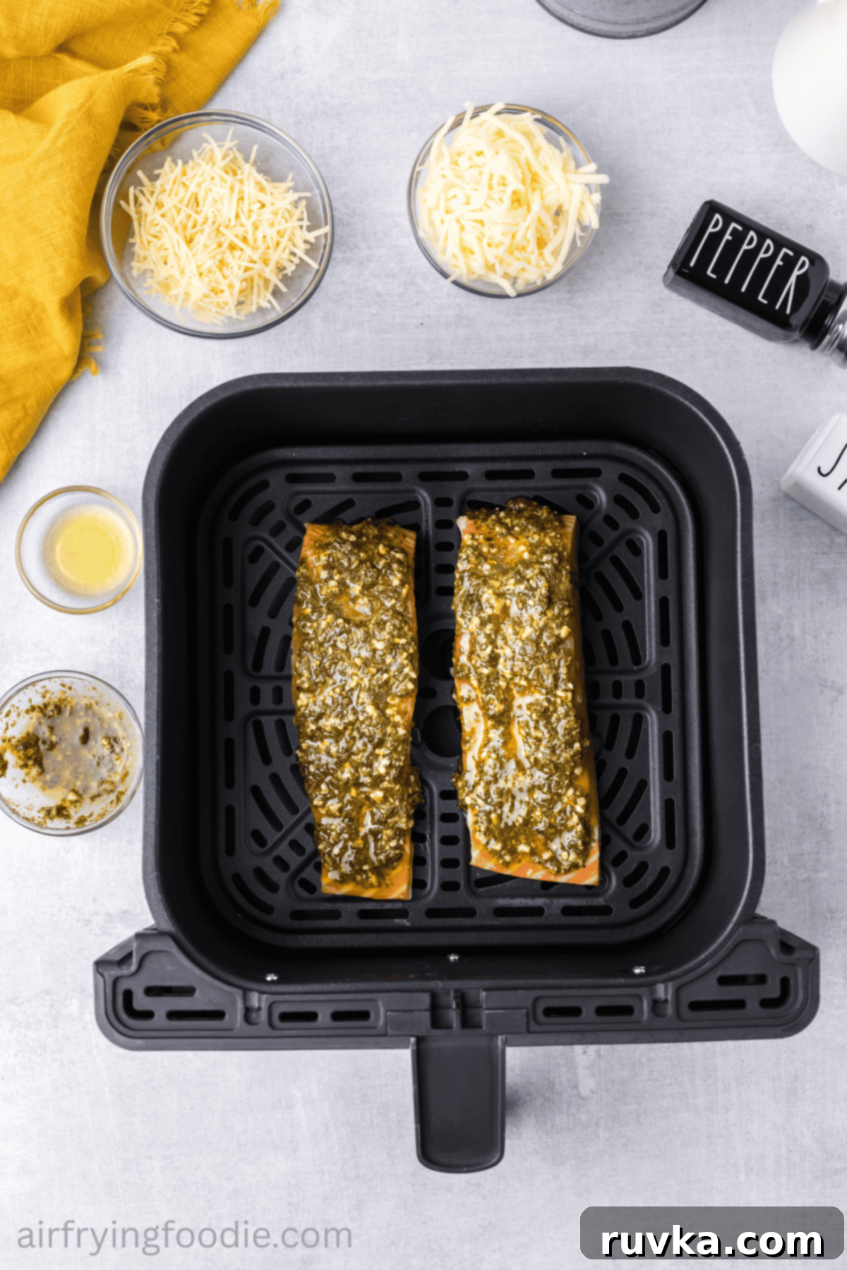 Crispy Air-Fried Pesto Parmesan Salmon 6 Salmon fillets evenly topped with fresh basil pesto, ready for the cheese layer.