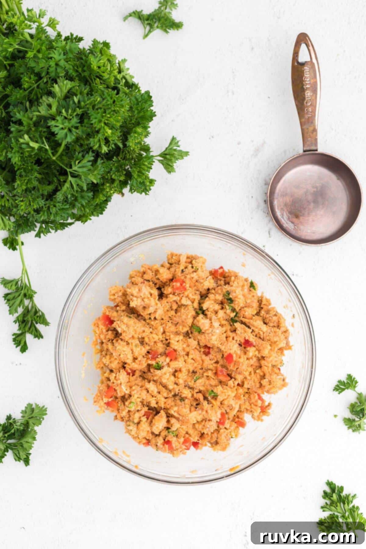 Crispy Air Fryer Salmon Cakes 4 Shredded salmon with chopped bell peppers and seasonings mixed in a clear glass bowl.