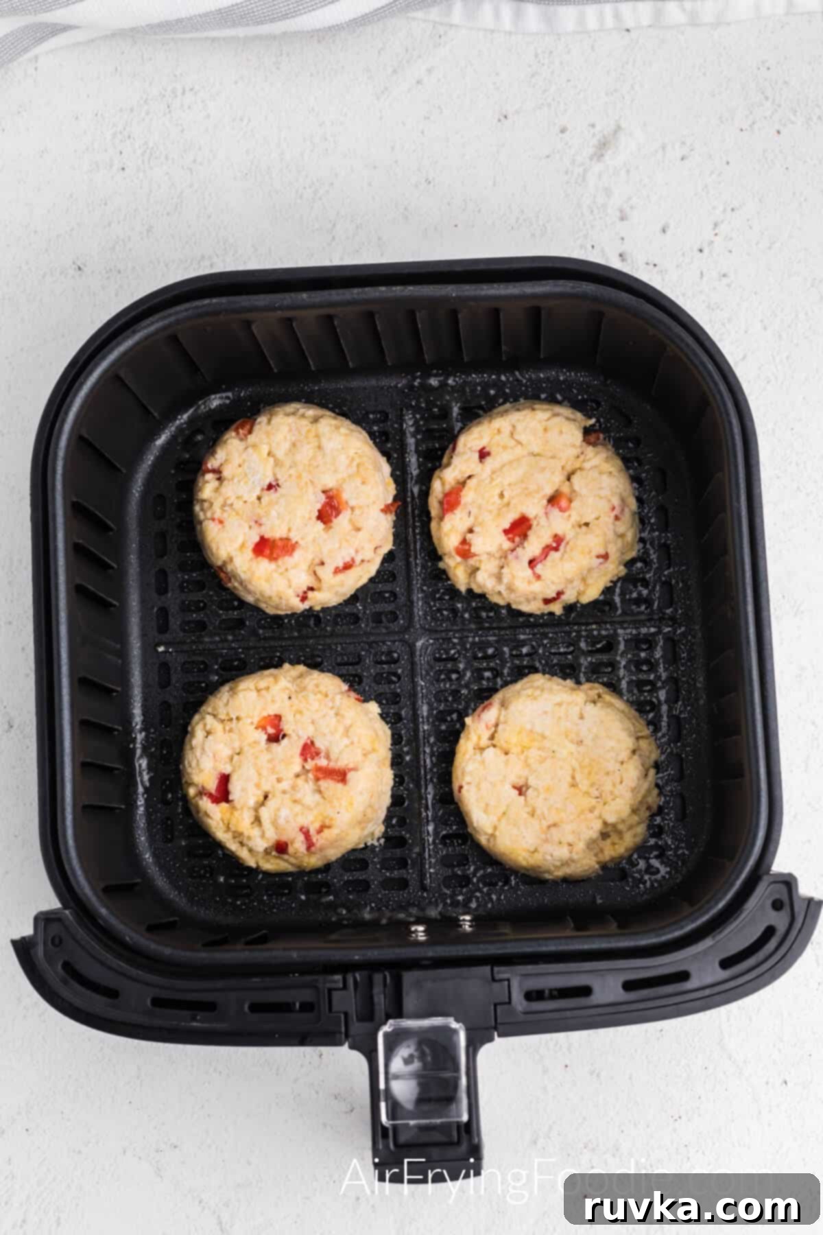 Crispy Air Fryer Crab Cakes 6 Crab cakes placed in the air fryer basket, ready to be cooked.