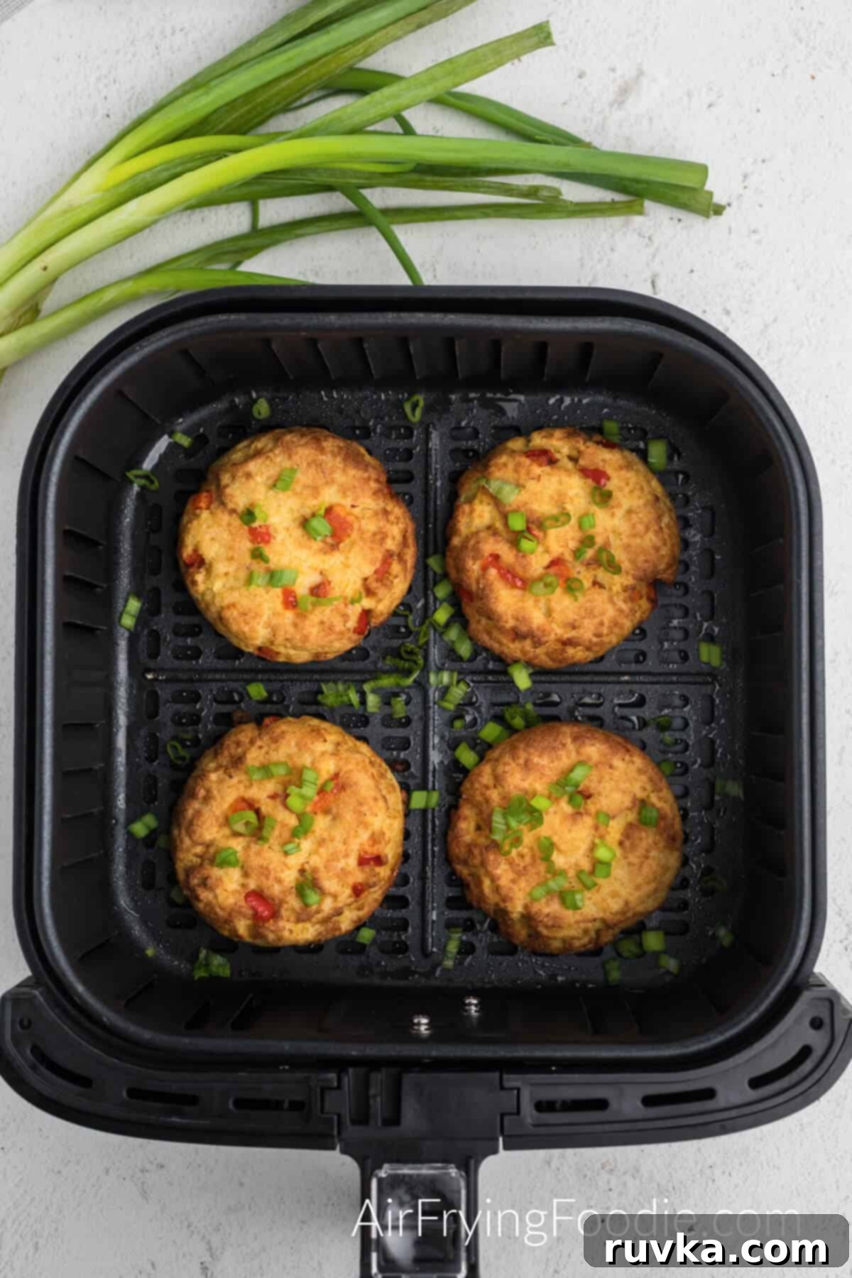 Crispy Air Fryer Crab Cakes 7 Crab cake patties cooking in the air fryer basket.