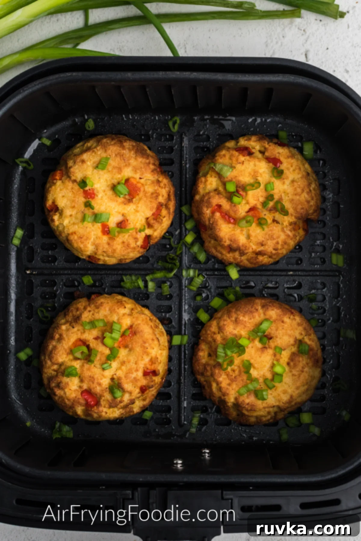 Crispy Air Fryer Crab Cakes 9 Close-up of air fried crab cakes in the air fryer basket, showing their golden-brown crust.