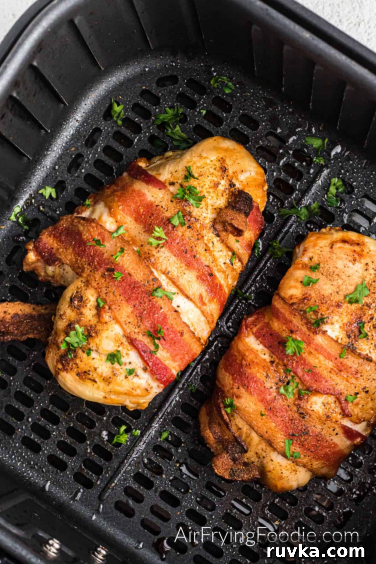 Crispy Air Fryer Bacon Chicken 2 Bacon wrapped chicken in air fryer basket, ready to serve.