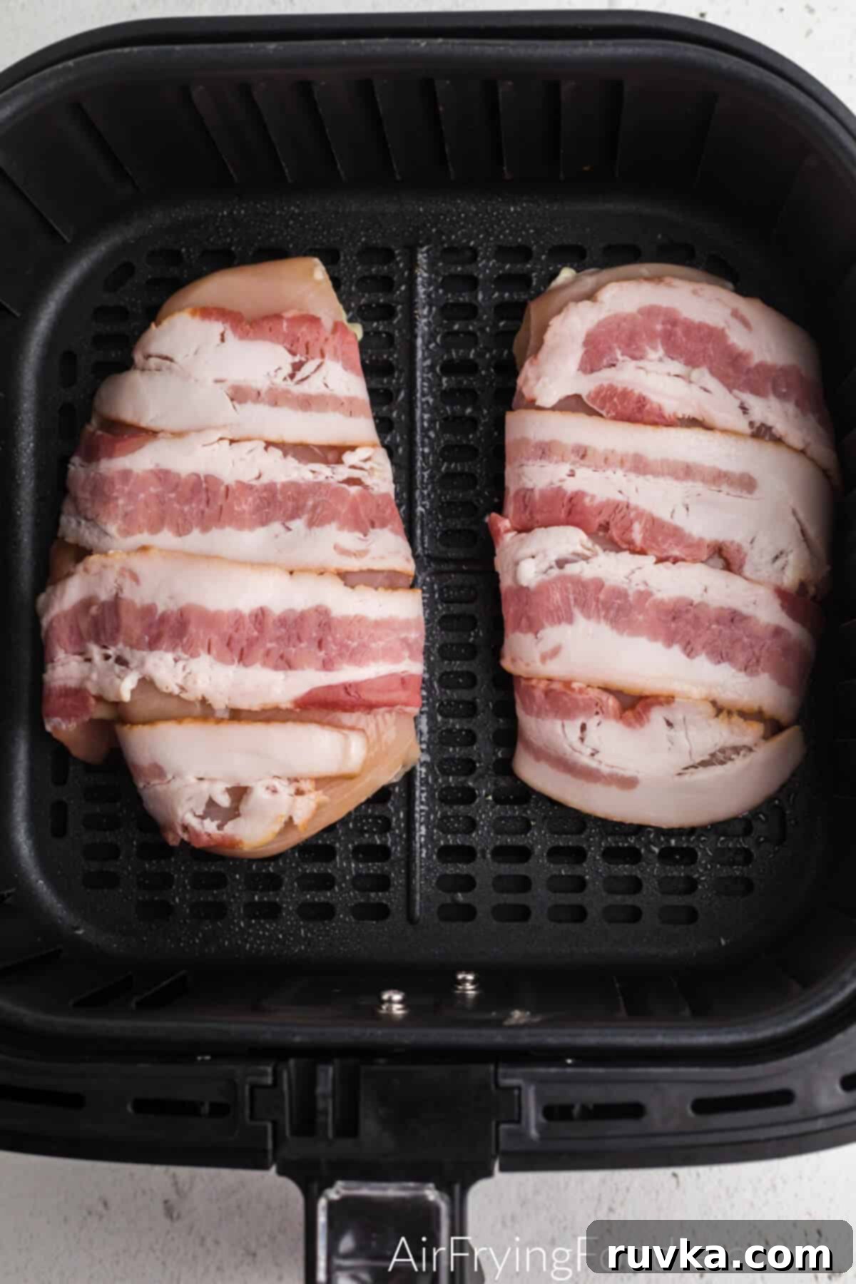 Crispy Air Fryer Bacon Chicken 4 Chicken wrapped in bacon and place into the basket of the air fryer.