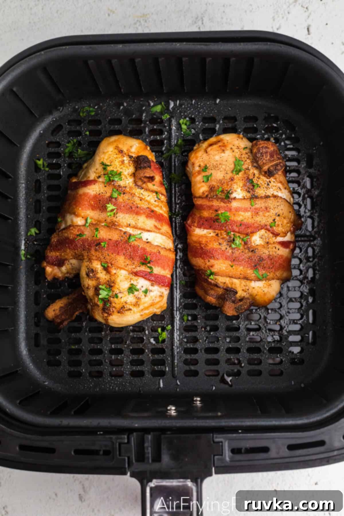 Crispy Air Fryer Bacon Chicken 5 Air fried bacon wrapped chicken in the basket of the air fryer.
