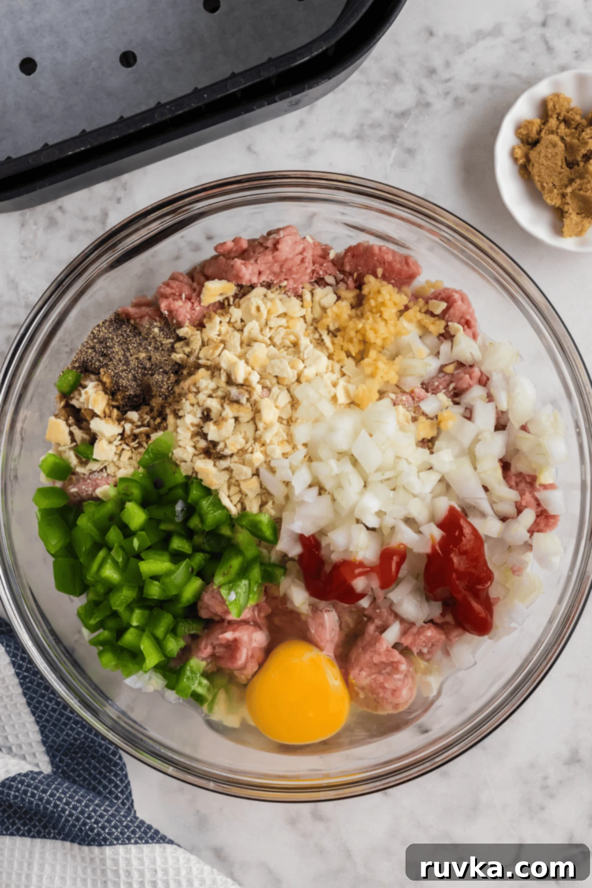 Large mixing bowl with ingredients to make turkey meatloaf.