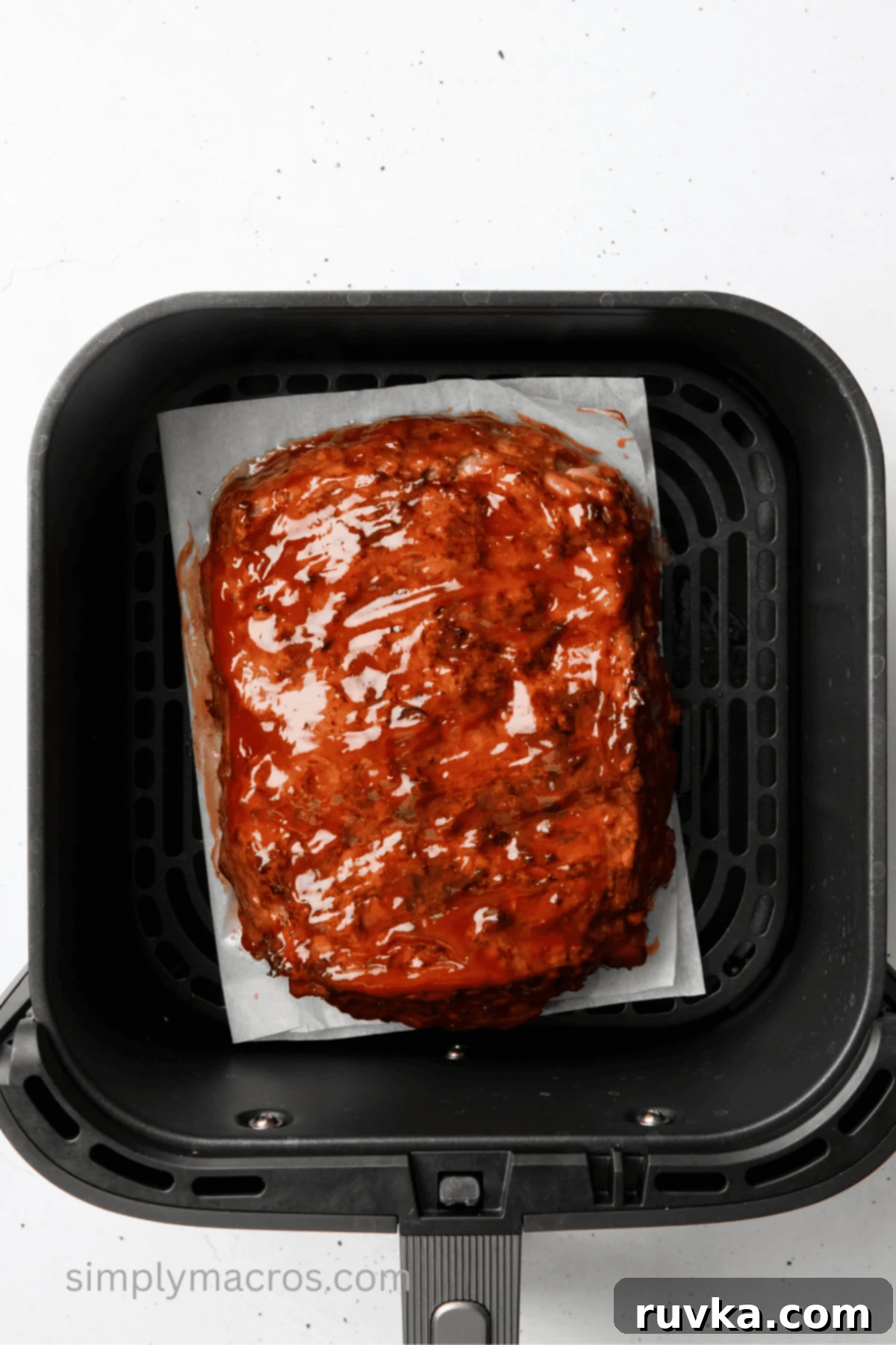 Turkey meatloaf in air fryer basket with glaze on top.