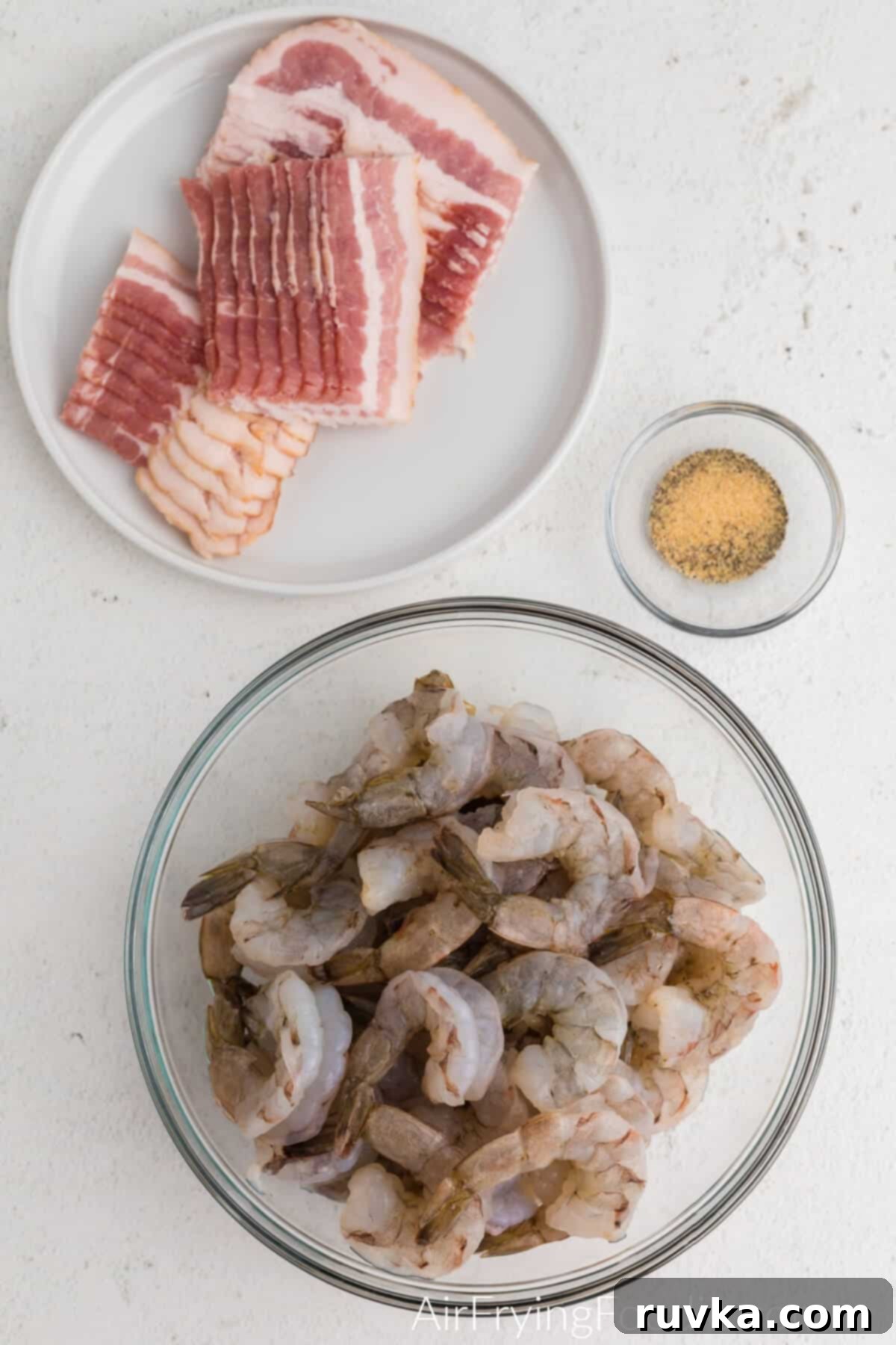 Crispy Air Fryer Bacon Wrapped Shrimp 3 Ingredients for bacon wrapped shrimp: peeled shrimp, slices of bacon, and Old Bay seasoning.