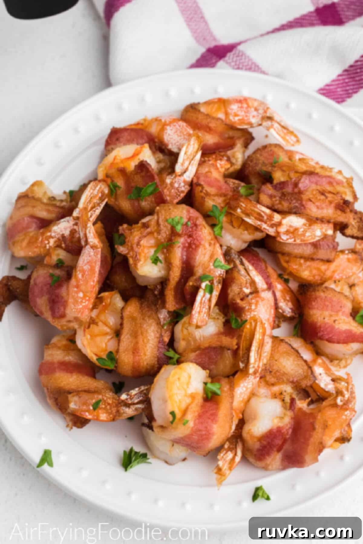 Crispy Air Fryer Bacon Wrapped Shrimp 6 A plate of freshly cooked air fryer bacon wrapped shrimp, garnished and ready to be enjoyed.