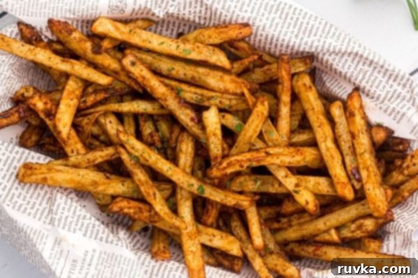 Crispy Air Fryer Seasoned Fries 2 Golden fries, seasoned and stacked in a paper lined basket with parsley flakes garnish.