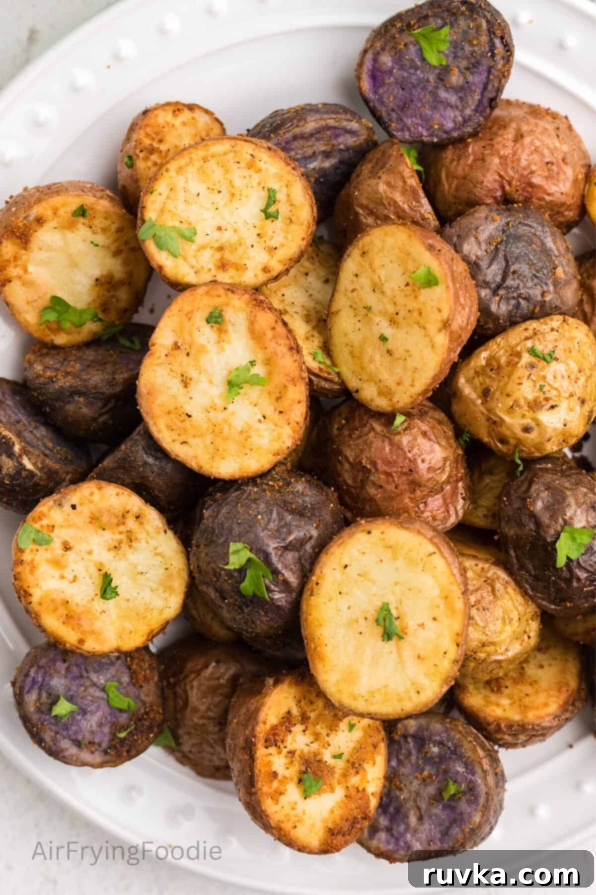 Crispy Air Fryer Roasted Potatoes 2 Crispy air fryer roasted potatoes, seasoned and served on a white plate.