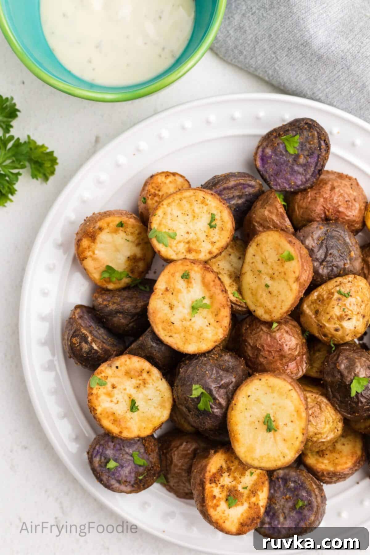 Crispy Air Fryer Roasted Potatoes 8 Crispy, roasted potatoes, made in the air fryer, on a white plate ready to eat.