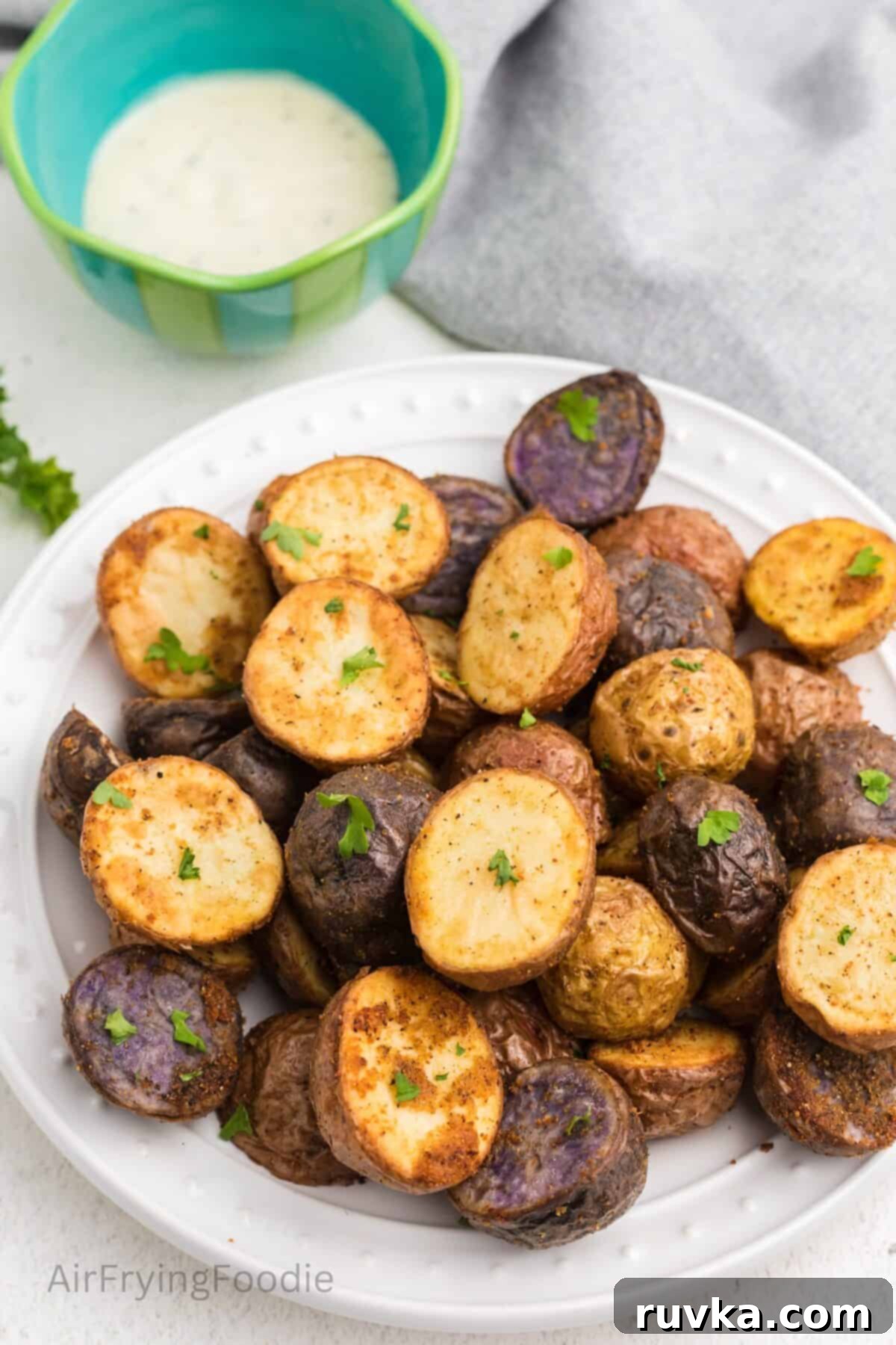 Crispy Air Fryer Roasted Potatoes 9 Roasted potatoes made in the air fryer, topped with chopped fresh parsley, and plated and ready to serve.