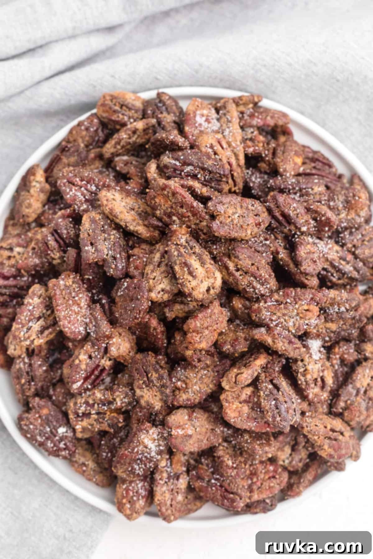 Golden Air Fryer Candied Pecans 8 Air fried candied pecans served in a ceramic bowl, ready to be enjoyed as a snack or dessert.