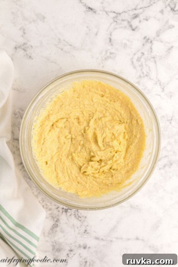 Air Fryer Cornbread Perfection 5 Mixing dry and wet ingredients for cornbread batter in a bowl.