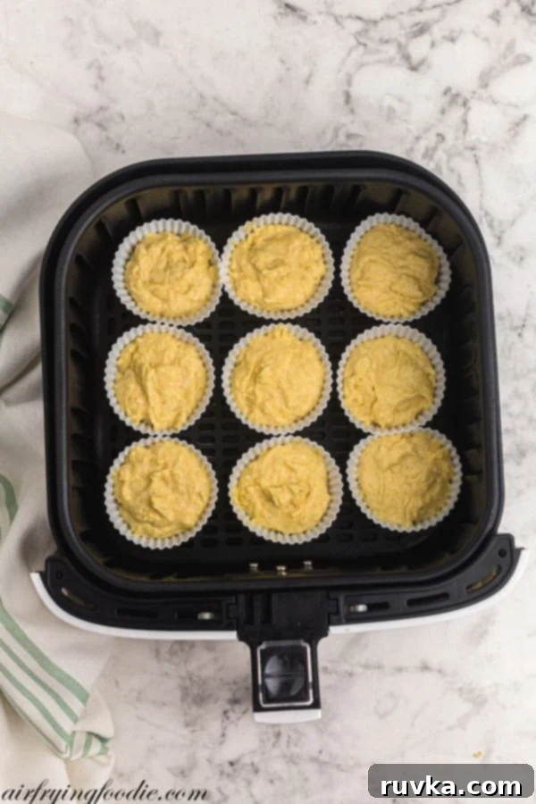 Air Fryer Cornbread Perfection 6 Silicone cups filled with cornbread batter before cooking in the air fryer.
