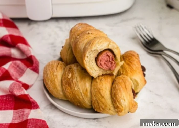 Crispy Air Fryer Pretzel Dogs 8 Golden pretzel dogs stacked with one missing a bite.
