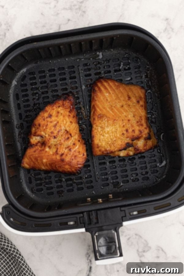 Effortless Air Fryer Honey Mustard Salmon 5 Perfectly cooked, glazed honey mustard salmon resting in the air fryer basket, boasting a golden-brown finish, ready to be served.