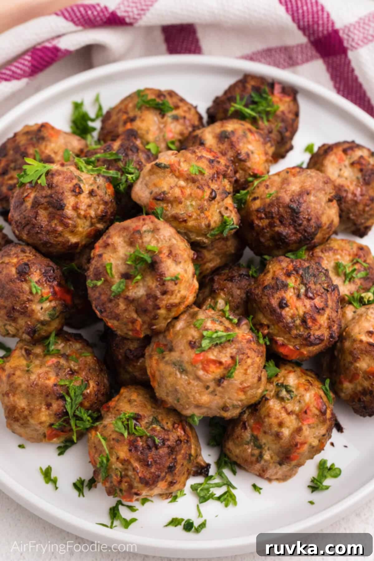 Crispy Air-Fried Turkey Meatballs 2 Air fryer turkey meatballs on a white plate with fresh parsley, ready to eat.