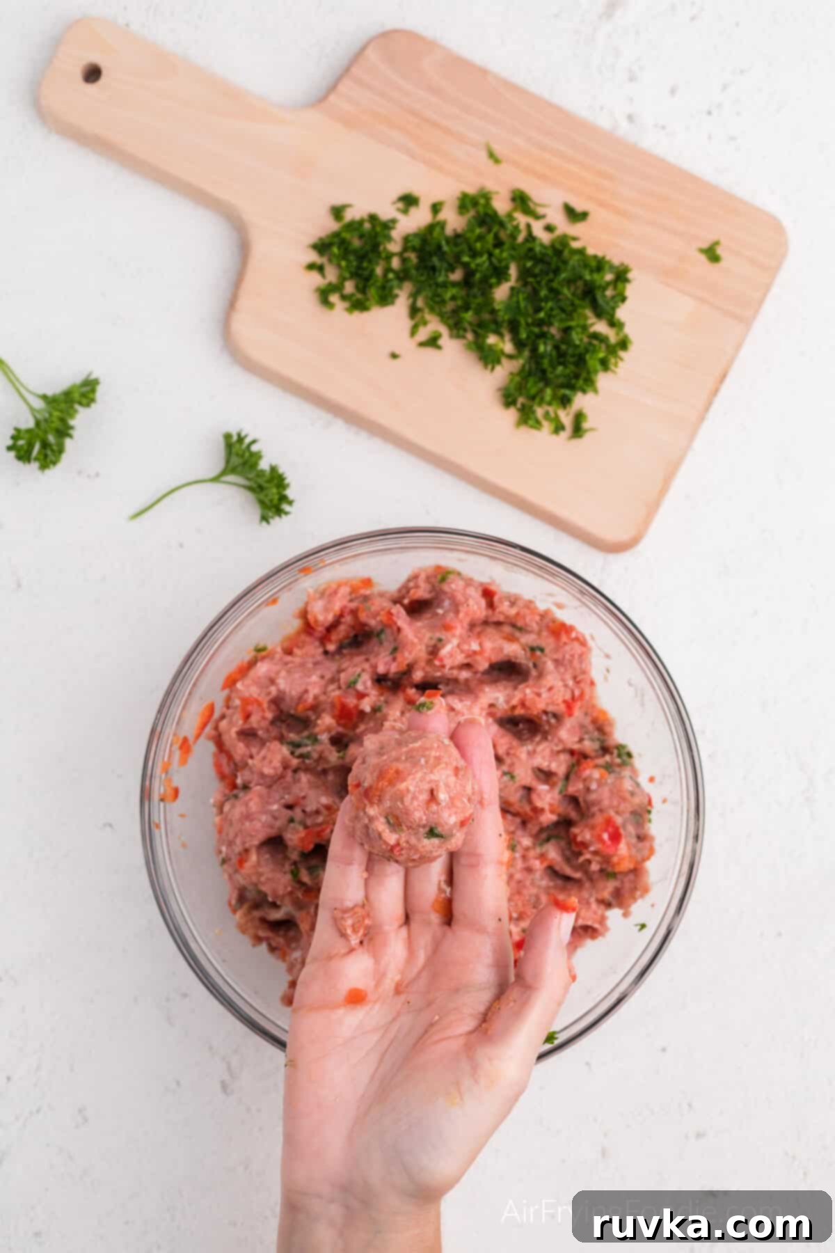 Crispy Air-Fried Turkey Meatballs 6 Hand holding a scooped and shaped meatball with the turkey and ingredients.