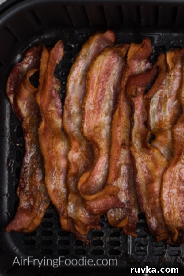 Crispy Air Fryer Bacon 5 cooked crispy bacon in the basket of the air fryer.