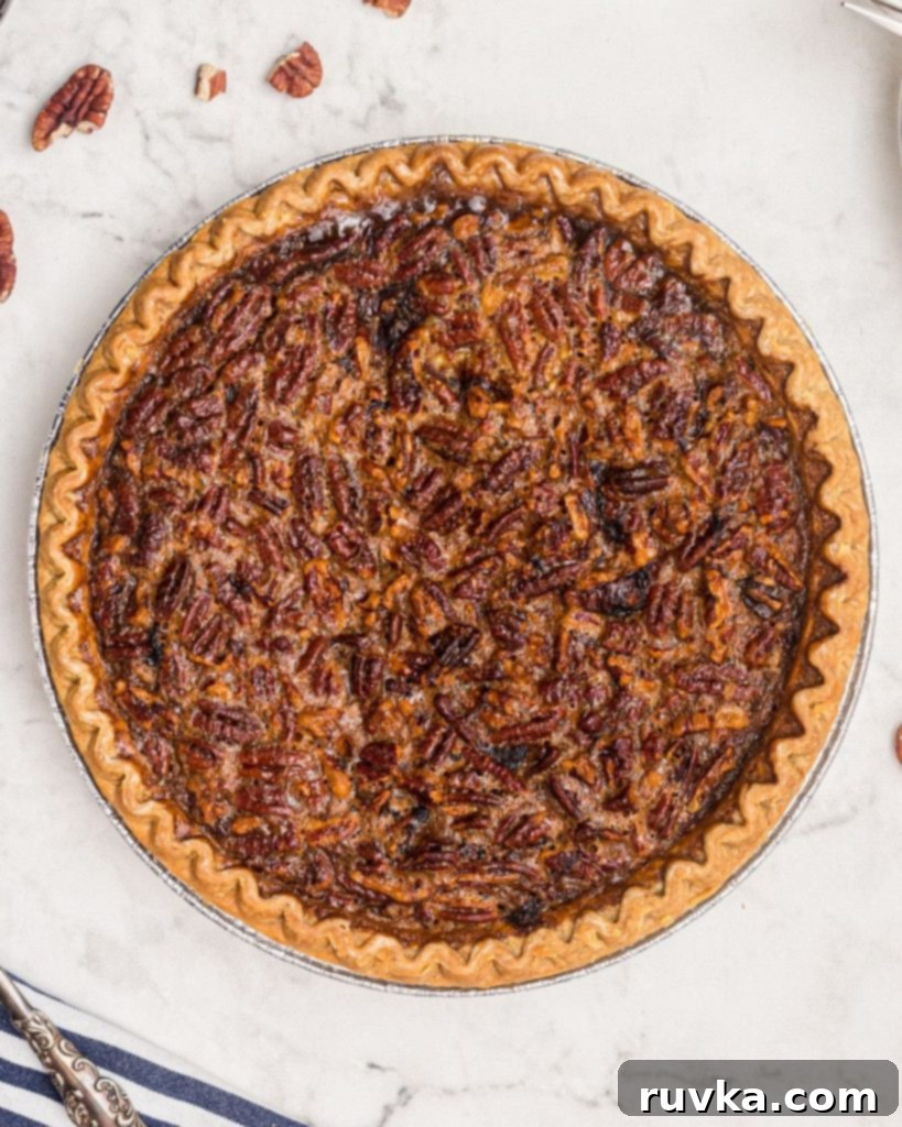 Perfect Air Fryer Pecan Pie 8 A close-up shot of the glistening, nutty top of a baked pecan pie, highlighting its appealing texture and rich color.