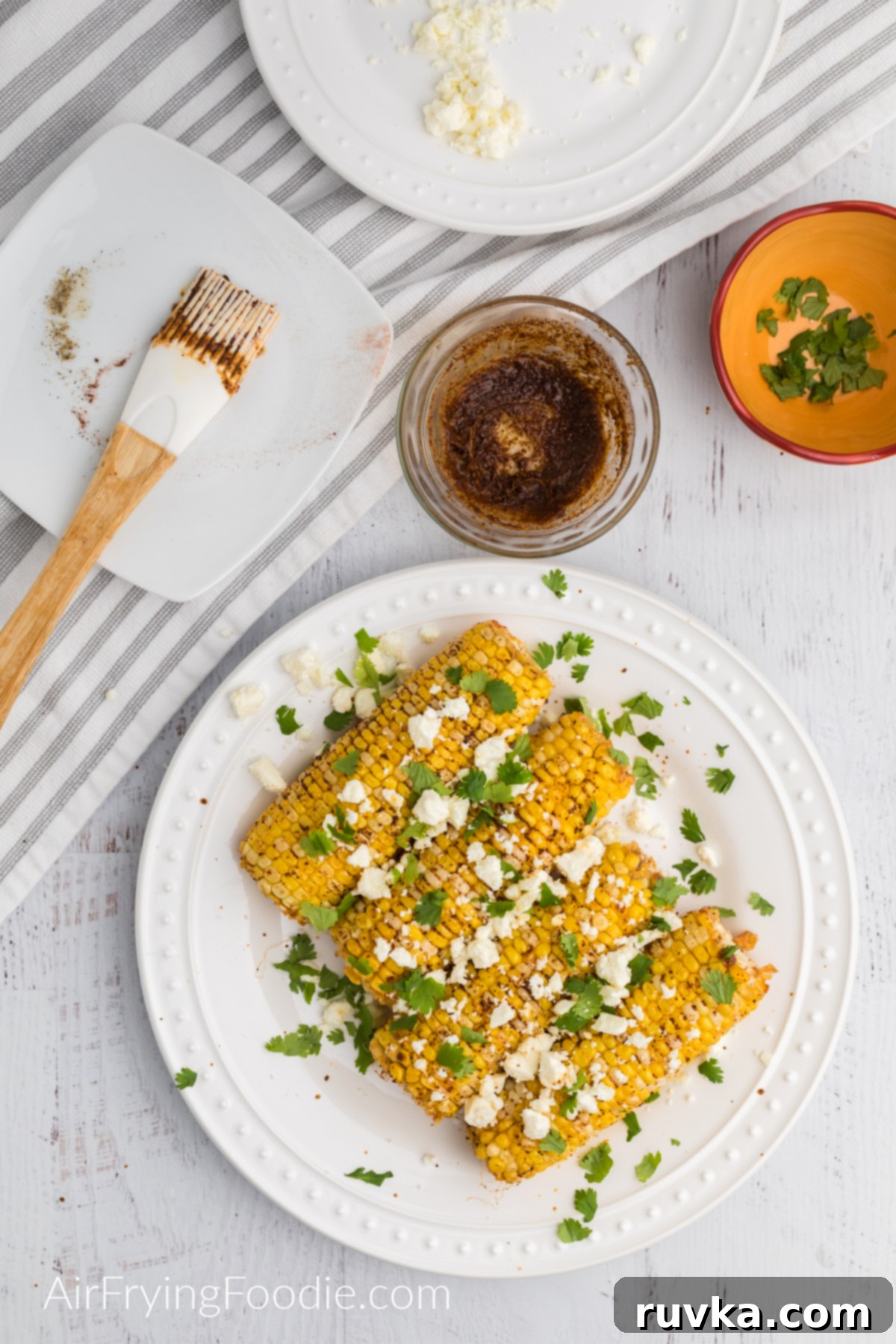 Crispy Air Fryer Elote 6 Cooked corn topped with feta cheese and fresh chopped cilantro.