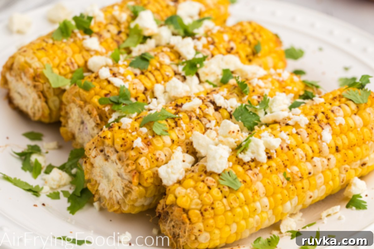 Crispy Air Fryer Elote 7 Close up photo of air fryer Mexican street corn on a white plate ready to eat.
