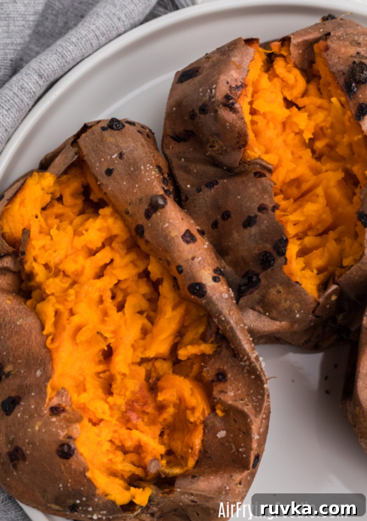 Perfect Air Fryer Sweet Potatoes 2 Cooked and sliced baked sweet potatoes made in the air fryer, ready to be topped.