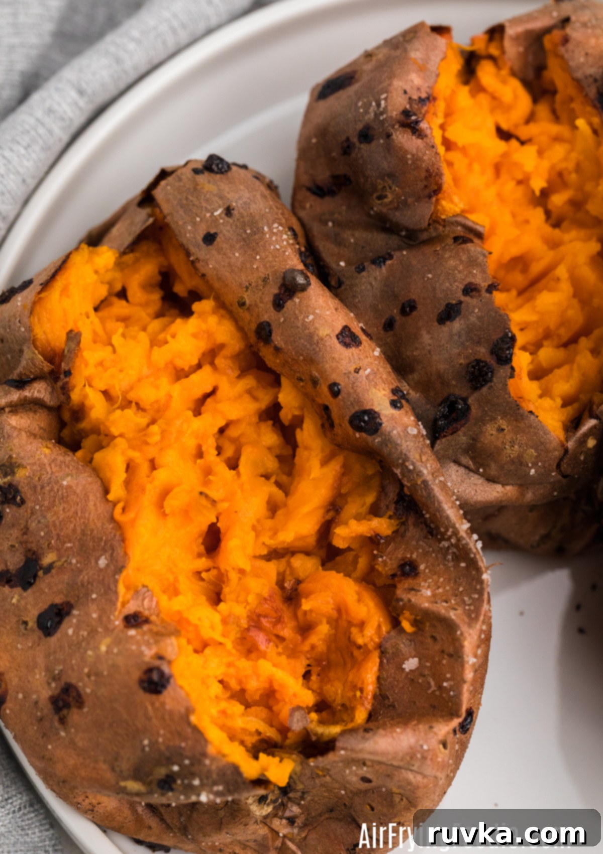 Perfect Air Fryer Sweet Potatoes 5 Close up photo of baked sweet potatoes that were made in the air fryer - sliced open and ready for toppings.